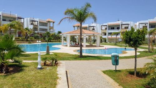 una piscina con gazebo in un resort di Rosewood, un appartement de rêve à Asilah Marina Golf a Asilah