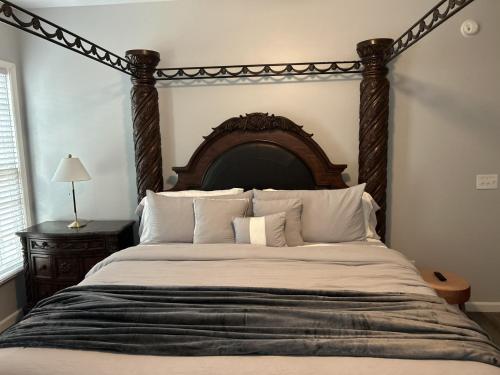 a bedroom with a large bed with a wooden headboard at Favored Stay in Savannah