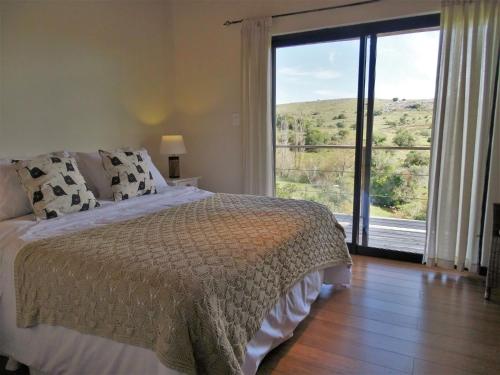 a bedroom with a bed and a large window at Valle del Hilo de la Vida in Minas