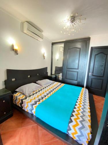 a bedroom with a large bed with a colorful blanket at شاليه للإيجار في بورتو مارينا الساحل الشمالي العلمين 34 in El Alamein