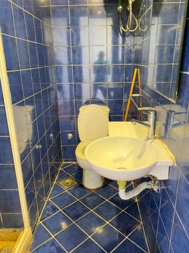 a blue tiled bathroom with a toilet and a sink at شاليه للإيجار في بورتو مارينا الساحل الشمالي العلمين 34 in El Alamein