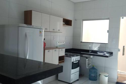 a kitchen with a white refrigerator and a sink at Casa Mobiliada Nova em Petrolina in Petrolina