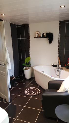 La salle de bains est pourvue d'une baignoire et d'une plante. dans l'établissement CLOS BIOLETTE, à Vismes