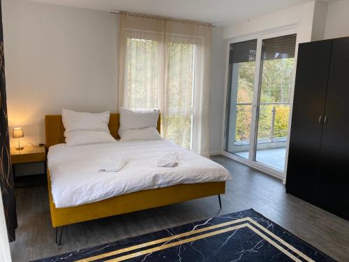 a bedroom with a bed with white sheets and a window at Valley of Business Frankfurt-West - Penthouse Nº2 - Three-Bedroom in Hofheim am Taunus