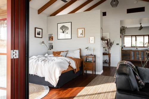 a bedroom with a bed and a couch at Kestrel Nest EcoHut in Mount Adrah