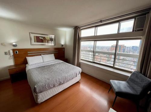 een slaapkamer met een bed en een groot raam bij Apartamento para 2 con gran Piscina in Santiago