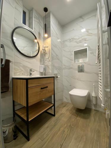 a bathroom with a sink and a toilet and a mirror at Levendula Vendégház in Győr