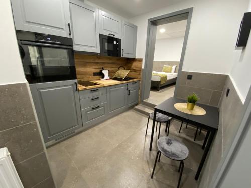 a kitchen with a table and some chairs in a room at Levendula Vendégház in Győr