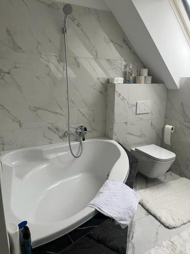 a bathroom with a white tub and a toilet at B-Apartment Vienna 12 in Vienna