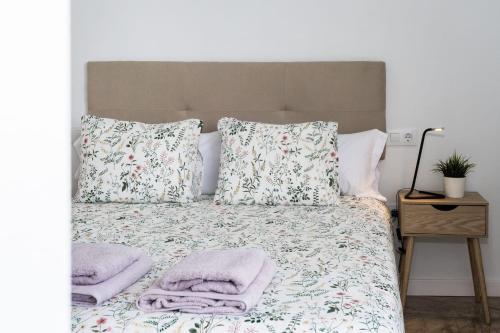 Una cama con almohadas y toallas. en Casa volcán de caldera blanca en Tinguatón