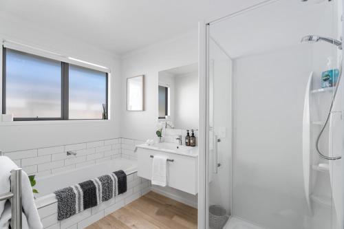 a white bathroom with a sink and a shower at Alpha'N'est - Cromwell Holiday Home in Cromwell