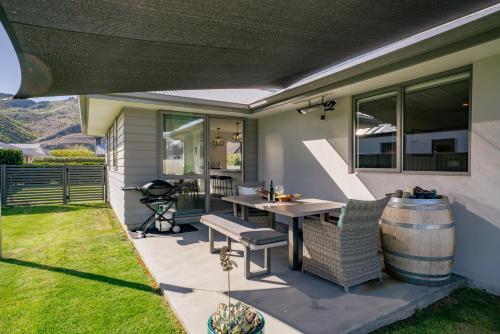 a patio with a table and chairs and a barrel at Alpha'N'est - Cromwell Holiday Home in Cromwell