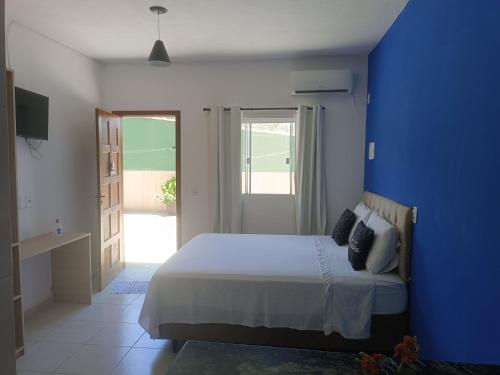 um quarto azul com uma cama e uma parede azul em Flats 1 Locação Penedo RJ em Penedo