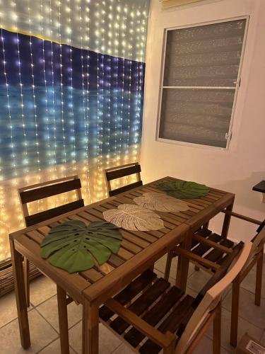 una mesa de comedor con sillas y una ventana con luces en Tropicoco Pool House Steps From The Beach, en Puerto Nuevo