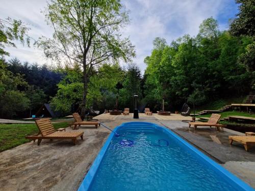 a swimming pool with two chairs and a table at Ecos del Manantial in Villarrica