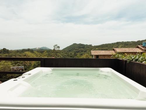 una vasca da bagno posta in cima a un balcone di Pousada Solar dos Lírios - Praia do Rosa a Praia do Rosa