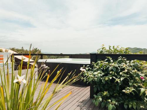 una terraza con flores y plantas en el balcón en Pousada Solar dos Lírios - Praia do Rosa en Praia do Rosa
