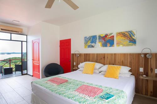 a bedroom with a large bed with a red door at Pura Vista Hotel in Ocotal