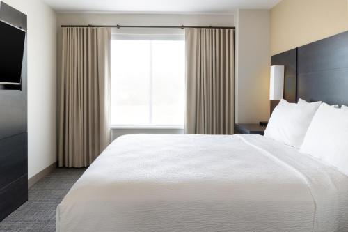 a hotel room with a large bed and a window at Residence Inn by Marriott Corona Riverside in Corona