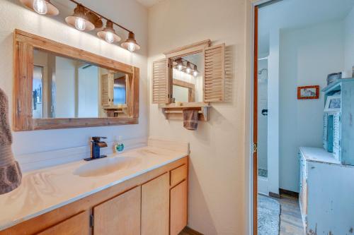 a bathroom with a sink and a mirror and a refrigerator at Munds Park Cabin with Deck and Golf Course Views in Munds Park