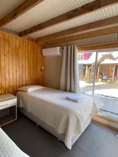 a bedroom with a bed and a window at Baño Privado, Desayuno, Calefacción, 1 Persona in Villa Cerro Castillo