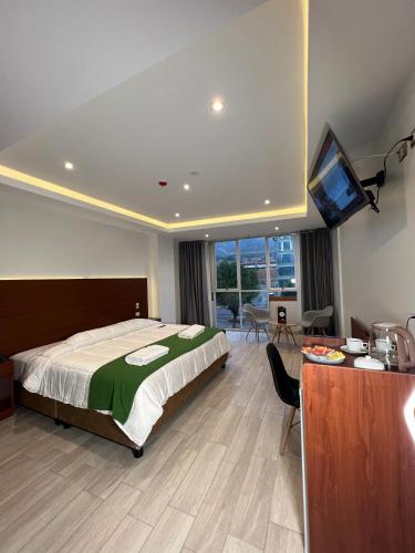 a bedroom with a bed and a flat screen tv at EL ALAMO, EJECUTIVO Y SPA in Cusco