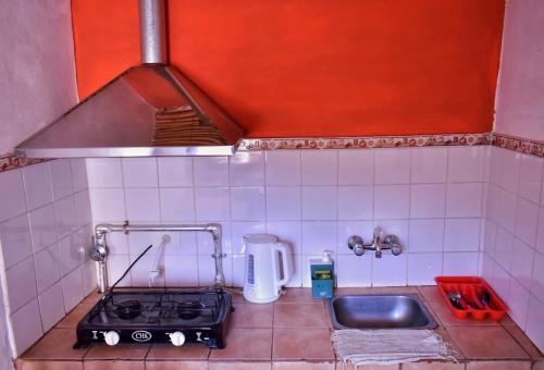 a small kitchen with a stove and a sink at Cabañas Tierra Andina in Tilcara