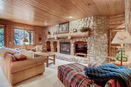 a living room with a stone fireplace in a cabin at Black Bear Lodge in Park City