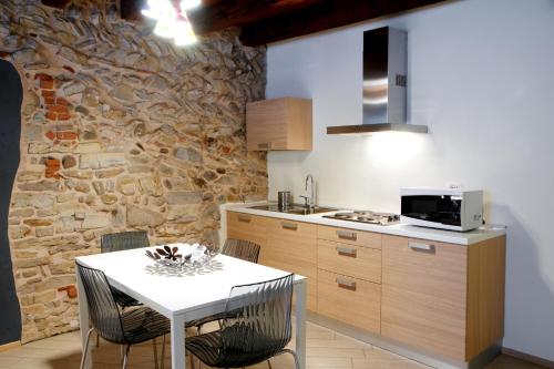 cocina con mesa blanca y pared de piedra en B&B Home Sweet Home, en Bérgamo
