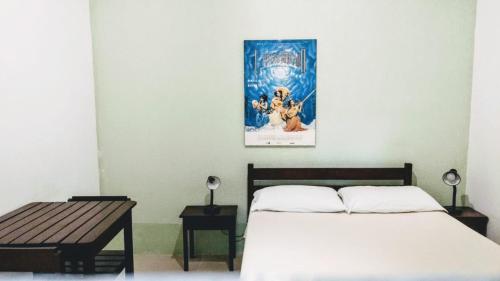 1 dormitorio con 1 cama y una foto en la pared en Suítes a 50 metros da Rua das Pedras, en Búzios