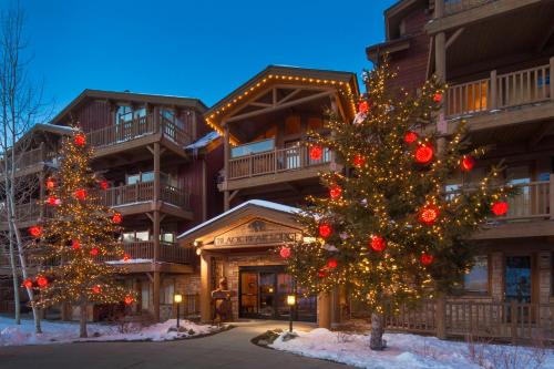 two christmas trees in front of a lodge at Black Bear Lodge in Park City