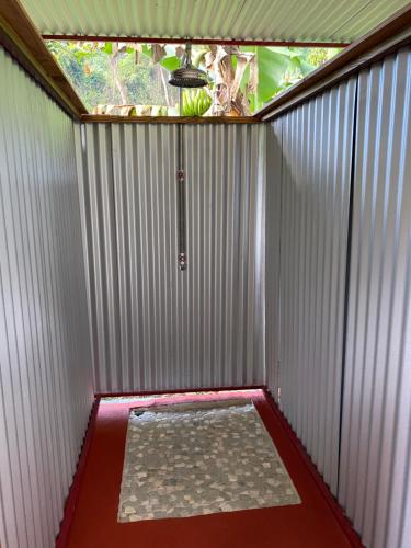 a small shower with a window and a red floor at Fare Hau Camp in Patio