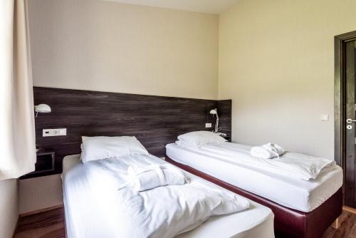2 łóżka w pokoju hotelowym z białą pościelą w obiekcie Boutique Hotel Anna by EJ Hotels w mieście Holt