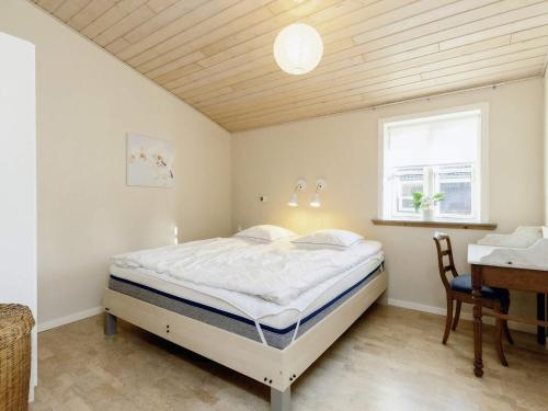 Schlafzimmer mit einem Bett, einem Schreibtisch und einem Fenster in der Unterkunft Holiday home Nysted IX in Nysted