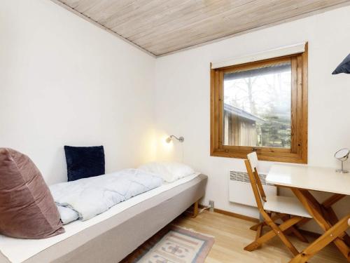 1 dormitorio con cama, escritorio y ventana en Holiday home Gedser XXXV, en Gedser