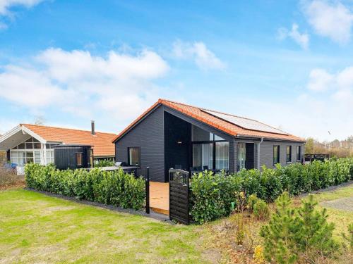 a black house with a garden in front of it at Modern Oasis in Marielyst - By Traum Ferienwohnungen in Marielyst