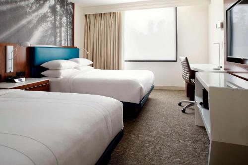 a hotel room with two beds and a desk at Raleigh Marriott Crabtree Valley in Raleigh
