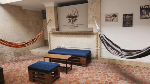 a room with a bench and a table and hammocks at Paisa Hostel Medellín in Medellín