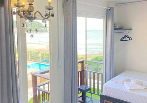 a bedroom with a view of the ocean from a balcony at Pousada São Miguel Beach Beira Mar in Penha