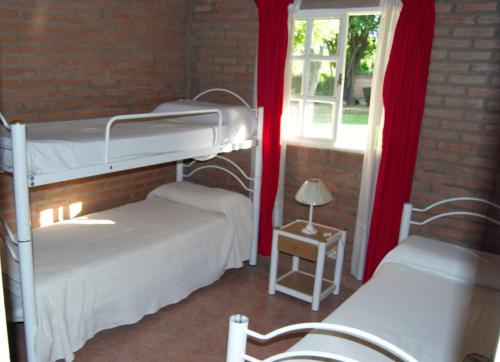 a bedroom with two bunk beds and a window at Complejo Arco Iris in Villa Cura Brochero