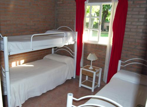 1 dormitorio con 2 literas y ventana en Complejo Arco Iris en Villa Cura Brochero