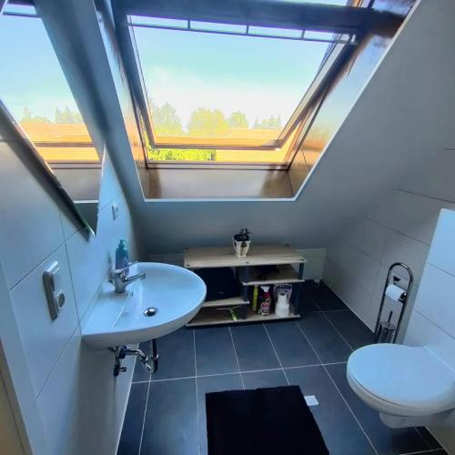 La salle de bains est pourvue d'un lavabo, de toilettes et d'une fenêtre. dans l'établissement Moderne Wohnung in ruhiger Lage, à Krefeld