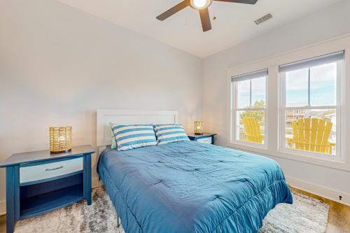 a bedroom with a blue bed and a window at Of Course You Can in Holden Beach