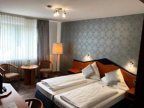 a hotel room with a bed and a table and chairs at Hotel 9-enhof in Wuppertal