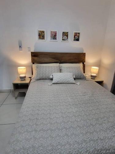 a bedroom with a large bed with two lamps at Apartamento #6 cómodo, Tranquilo, Elegante cerca de la estación del metro de la cincuentenario in Panama City
