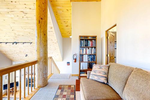 a living room with a couch and a book shelf at Peter's Place in Angel Fire