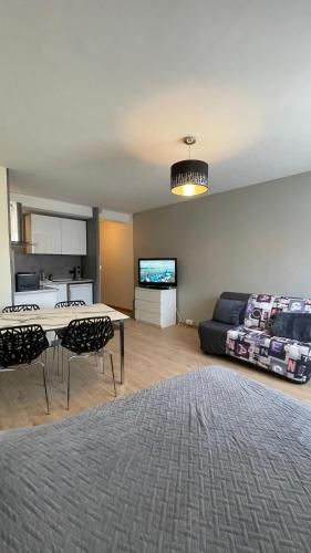 un salon avec une table et un canapé dans l'établissement GRAND STUDIO proche du centre ville, à Strasbourg