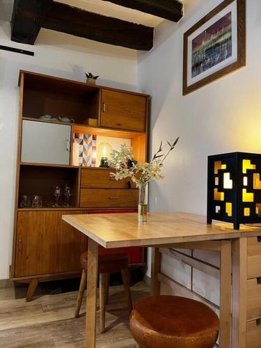 une table de salle à manger avec un vase de fleurs dessus dans l'établissement Appartement au Marais centre Paris, à Paris