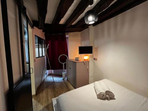 - une chambre avec un lit, une lampe et une télévision dans l'établissement Appartement au Marais centre Paris, à Paris
