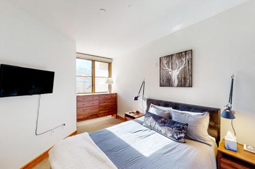 a bedroom with a bed and a flat screen tv at Palmyra 4E in Telluride